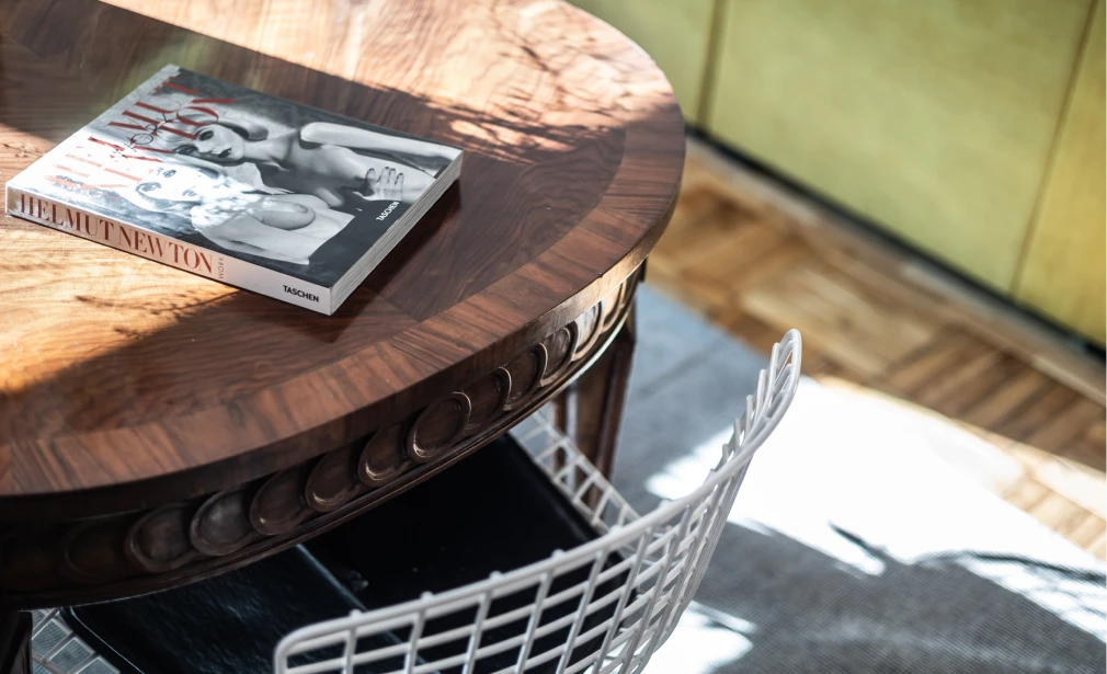 Detalle interior de Casa M3 con mesa de comedor de madera, silla metálica blanca y luz natural sobre el mobiliario